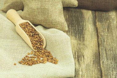 Tahta kaşıkta karabuğday. Karabuğday tohumları açık ahşap bir arkaplanda metin için boş alan ile (boşluğu kopyala)