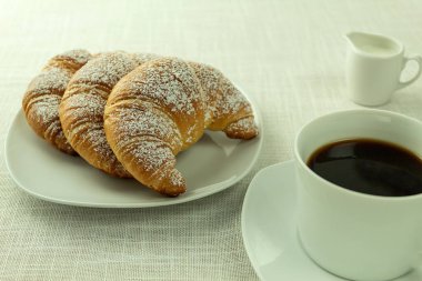 Kahvaltıda kahveli kruvasan ve mesaj atmak için yer. Bir kapuçino ve kruvasan. Metin için alanı kopyala