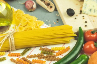 Baharatlı ve sebzeli makarna ve spagetti. Makarna ve malzemelerin fotoğrafı. Metin için alanı olan arkaplan
