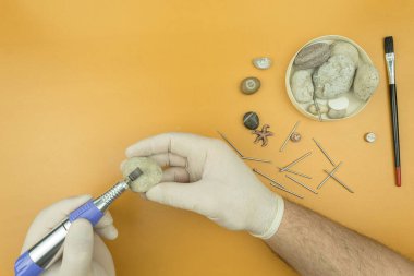 Bir oyma makinesiyle taş işleme. Adamın elleri bir oymacı tarafından taşın üzerine kazınmış. Taş ve metale profesyonel oyma. Metin için yeri olan arkaplan