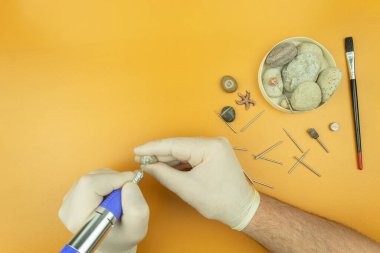 Bir oyma makinesiyle taş işleme. Adamın elleri bir oymacı tarafından taşın üzerine kazınmış. Taş ve metale profesyonel oyma. Metin için yeri olan arkaplan