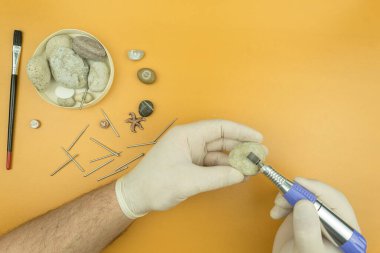 Bir oyma makinesiyle taş işleme. Adamın elleri bir oymacı tarafından taşın üzerine kazınmış. Taş ve metale profesyonel oyma. Metin için yeri olan arkaplan