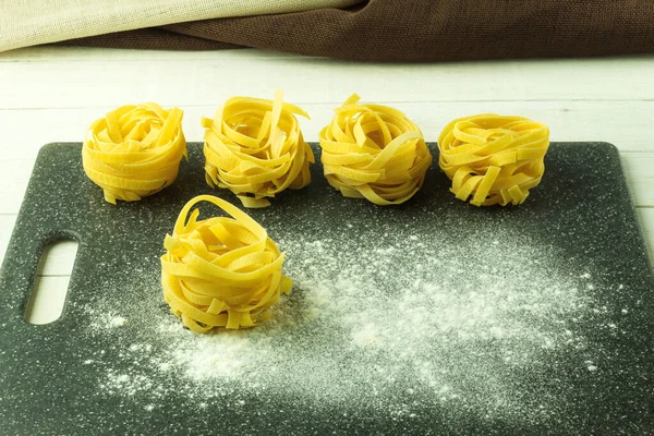 Twisted Noodles Flour Table Tagliatelle Pasta Form Nest Cutting Board — Stock Photo, Image