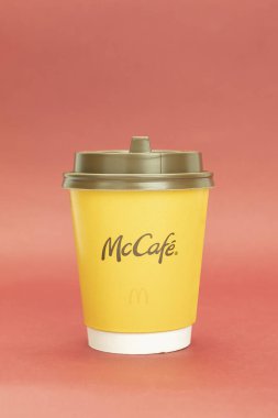 Varşova, Polonya - 26 Nisan 2021: McDonald 's logolu bir fincan kağıt kahve. Metin için alanı olan arkaplan