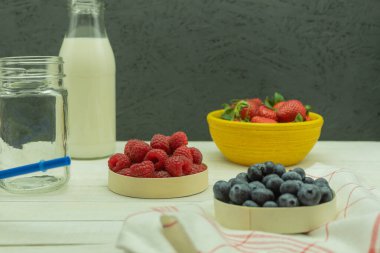 Milkshake yapmak için taze meyve ve süt. Çilekli muzlu içecek yapmak için gerekli malzemeler. Meyveli milkshake, metin için alanı olan arkaplan