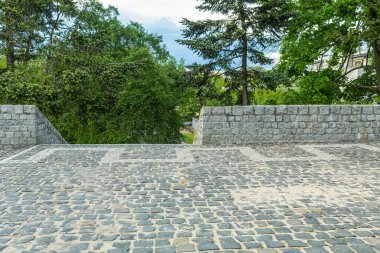 Granit taşlardan yapılmış çit ve merdiven. Taş kaldırım taşından çitleri olan kaldırımlı bir alan. Şehir parkında gözlem güvertesi
