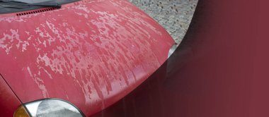 Arabanın kaputunda ve çatısında eski püskü bir cila var. Arabanın kaputundaki cila soyuluyor. Metin için alanı olan arkaplan