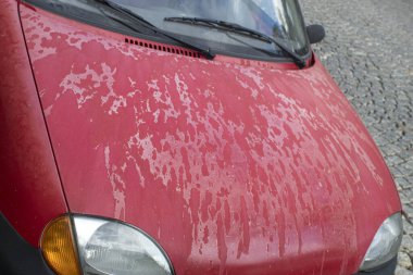 Arabanın kaputunda ve çatısında eski püskü bir cila var. Arabanın kaputundaki cila soyuluyor. Metin için alanı olan arkaplan