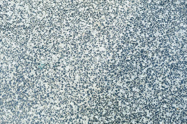 Texture of granite chips in concrete close-up. Colored granite floor, textured background. Concrete floor, strewn with scaly stone and smooth.