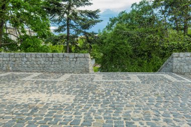 Granit taşlardan yapılmış çit ve merdiven. Taş kaldırım taşından çitleri olan kaldırımlı bir alan. Şehir parkında gözlem güvertesi