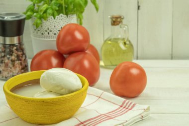 Lezzetli bir İtalyan Caprese salatası için yemek malzemeleri. Yiyecek malzemeleri - mozzarella, domates, fesleğen ve kırsal ahşap bir masada zeytinyağı. Metin için alanı olan arkaplan