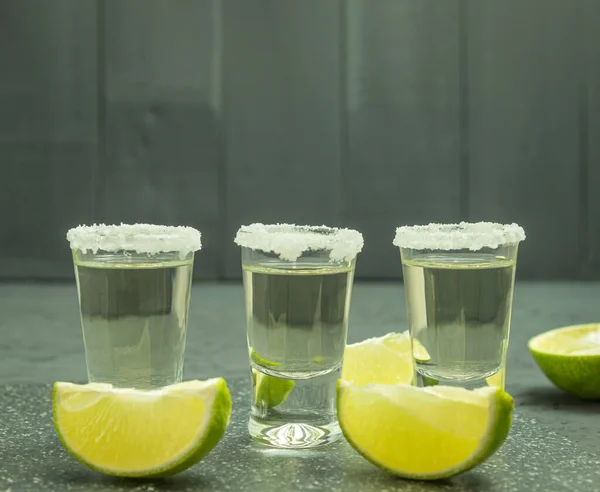 The glasses are filled with tequila and lime and salt. Aged tequila and lime stacks. Background with place for text