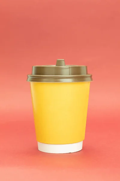 プラスチック蓋付きの黄色の紙コーヒーカップ 赤の背景に黄色のガラス テキストのためのスペースと — ストック写真