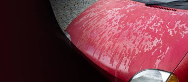 Arabanın kaputunda ve çatısında eski püskü bir cila var. Arabanın kaputundaki cila soyuluyor. Metin için alanı olan arkaplan