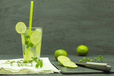 Bir bardak limonata ve limonlu buz. Ev yapımı mojito limonata, kireç ve naneli, kırsal bir masada cam bir kavanozda.