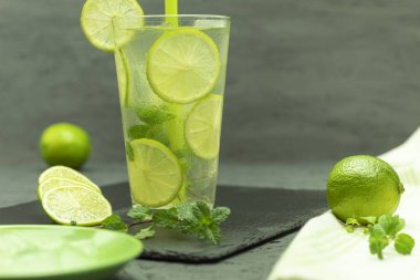 Bir bardak limonata ve limonlu buz. Ev yapımı mojito limonata, kireç ve naneli, kırsal bir masada cam bir kavanozda.