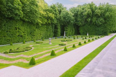 Yolları, çiçekleri ve ağaçları olan güzel bir şehir parkı manzarası. Sessiz yeşil bir parkta güzel bir doğa. Park iyi korunmuş.