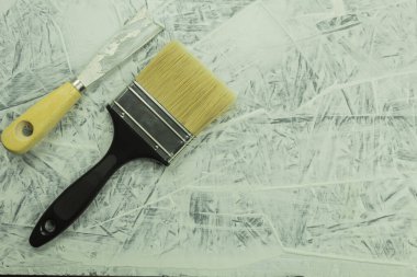 İşlem sırasında inşaat malası masanın üzerinde. Yenileme işlemi, kopyalama alanı olan arkaplan. Duvarın arka planında macun bıçağı var.