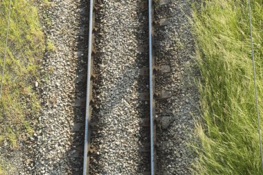 Demiryolu rayları ve beton yataklar, üst manzara. Çakıl taşlarıyla kaplı raylar ve yataklar.