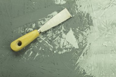 İşlem sırasında inşaat malası masanın üzerinde. Yenileme işlemi, kopyalama alanı olan arkaplan. Duvarın arka planında macun bıçağı var.