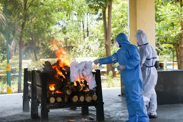 Vasai, Maharashtra, Hindistan - 04 Mayıs 2021: Kişisel Koruyucu Malzemeler (PPE) giyen belediye çalışanları, bir krematoryumda Covid-19 kurbanı yaktı. 