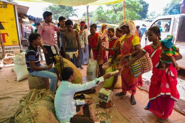 Jagdalpur, Bastar, Chhattisgarh, Hindistan / 29 Eylül 2017: Lohandiguda köy pazarından kabile kadınlarından pirinç satın alan bir tüccar. 