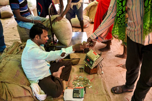 Jagdalpur, Bastar, Chhattisgarh, Hindistan / 29 Eylül 2017: Lohandiguda köy pazarından kabile kadınlarından pirinç satın alan bir tüccar. 