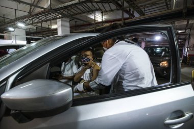 Mumbai, Maharashtra, Hindistan - 07 Mayıs 2021: Yaşlı bir adam COVID-19 aşısını almak için arabayla Dadar West 'teki Kohinoor otoparkındaki açık hava sinemasına gelir..