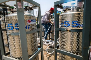 Ambernath, Maharashtra, Hindistan / 9 Mayıs 2021: Thane ilçesindeki çeşitli hastanelere ve Covid izolasyon merkezlerine COVID 19 virüsünün ikinci dalgası arasında tıbbi oksijen tüplerini dolduran özel bir şirketin çalışanı. 
