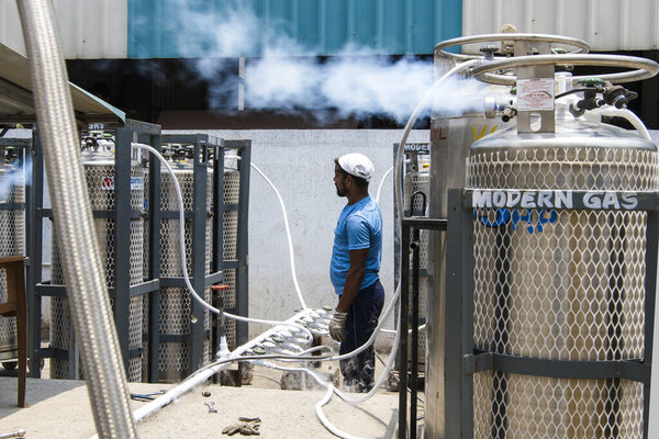 Амбернатх, Махараштра, Индия / 9 мая 2021 года: Работник частной компании, пополняющей медицинские кислородные баллоны для предстоящей поставки на фоне второй волны вируса COVID 19 в различные больницы и изоляционные центры Ковида в районе Тан. 