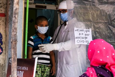 Mumbai / Hindistan - 9 Nisan 2020: Coronavirus salgını sırasında Dharavi varoşlarında bir doktor hastasını tedavi ediyor.