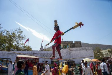 Junagad, Gujarat, Hindistan - 7 Mart 2016: Mahashivratri festivali kutlamaları sırasında genç bir kız dar bir ipte denge gösterisi yapıyor. 