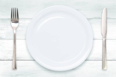 Pişirme şablonu - boş seramik beyaz bir tabağın üst görünümü ahşap bir eski masa üzerinde çatal bıçak ile