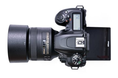 Krakow, Polonya - 09 Nisan 2021: Nikon D7500 DSLR kamerasının beyaz arka planda Nikkor 85 mm F1,8 lensli üst görüntüsü. Nikon optik ve görüntüleme ürünlerinde uzmanlaşmış ünlü bir Japon şirketidir..