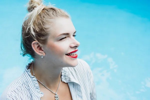 Mulher posando em uma piscina de água azul — Fotografia de Stock