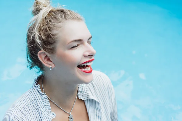 Donna in posa in una piscina di acqua blu — Foto Stock