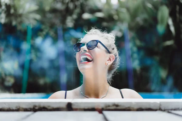 Mulher posando em uma piscina de água azul — Fotografia de Stock