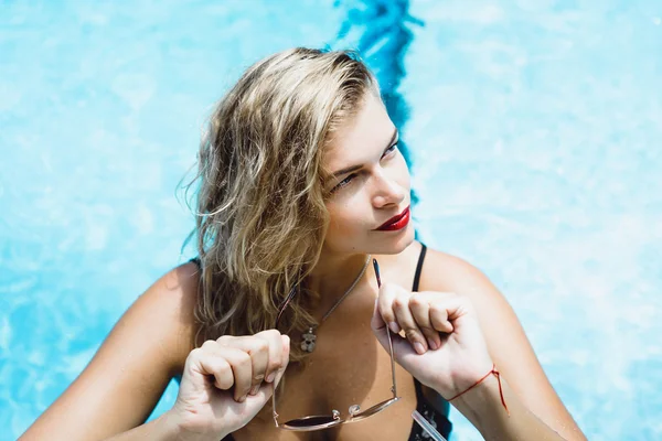 Женщина позирует в бассейне с голубой водой — стоковое фото