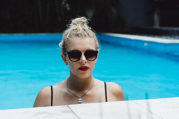 Mulher posando em uma piscina de água azul — Fotografia de Stock