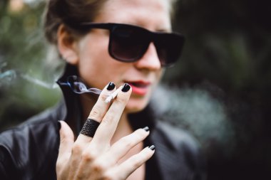 güzel bir kadın sigara içiyor.