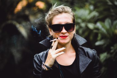 güzel bir kadın sigara içiyor.