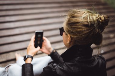 kadının elindeki cep telefonu ile