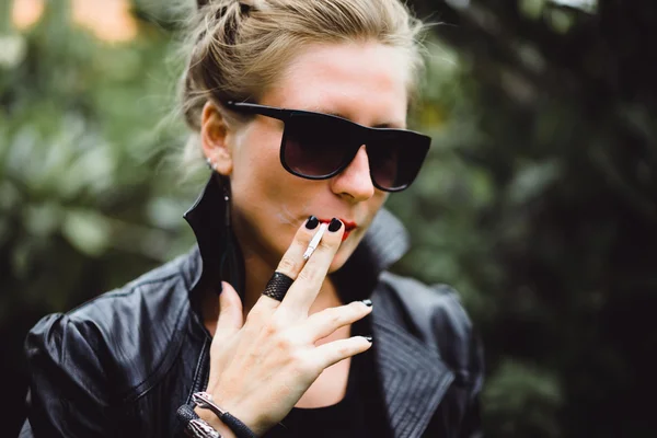 Vacker kvinna röker en cigarett. — Stockfoto