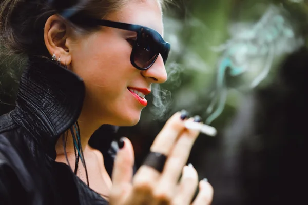 Vacker kvinna röker en cigarett. — Stockfoto
