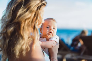 Anne bebeğiyle kumsalda.  