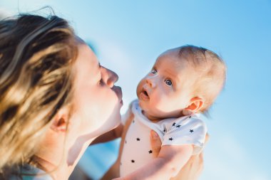  Anne bebeğiyle kumsalda.  