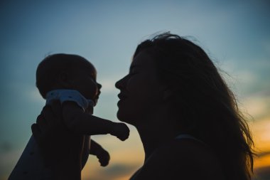  Anne bebeğiyle kumsalda.  