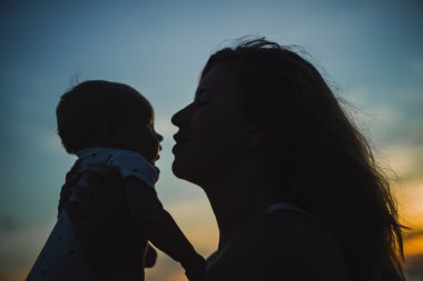  Anne bebeğiyle kumsalda.  