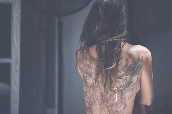 Dos d'une jeune fille avec un tatouage — Photo