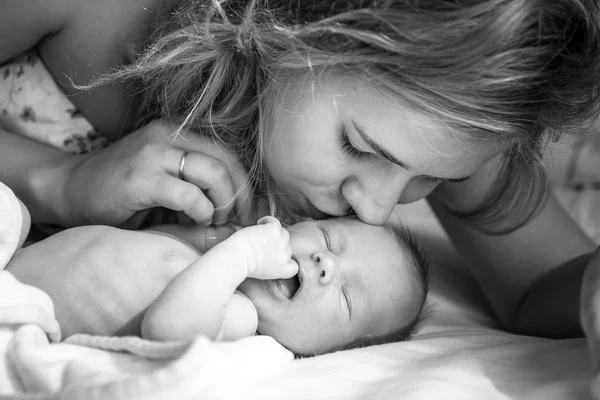 Mãe gentilmente kissisng bebê recém-nascido — Fotografia de Stock